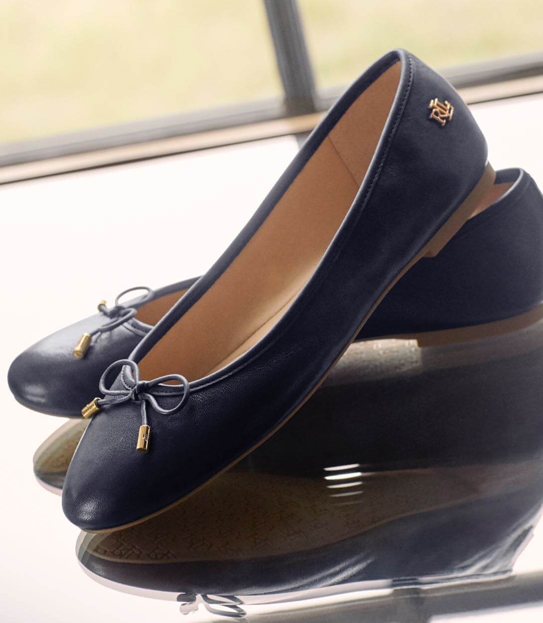 Navy leather flats with ties at the toe.