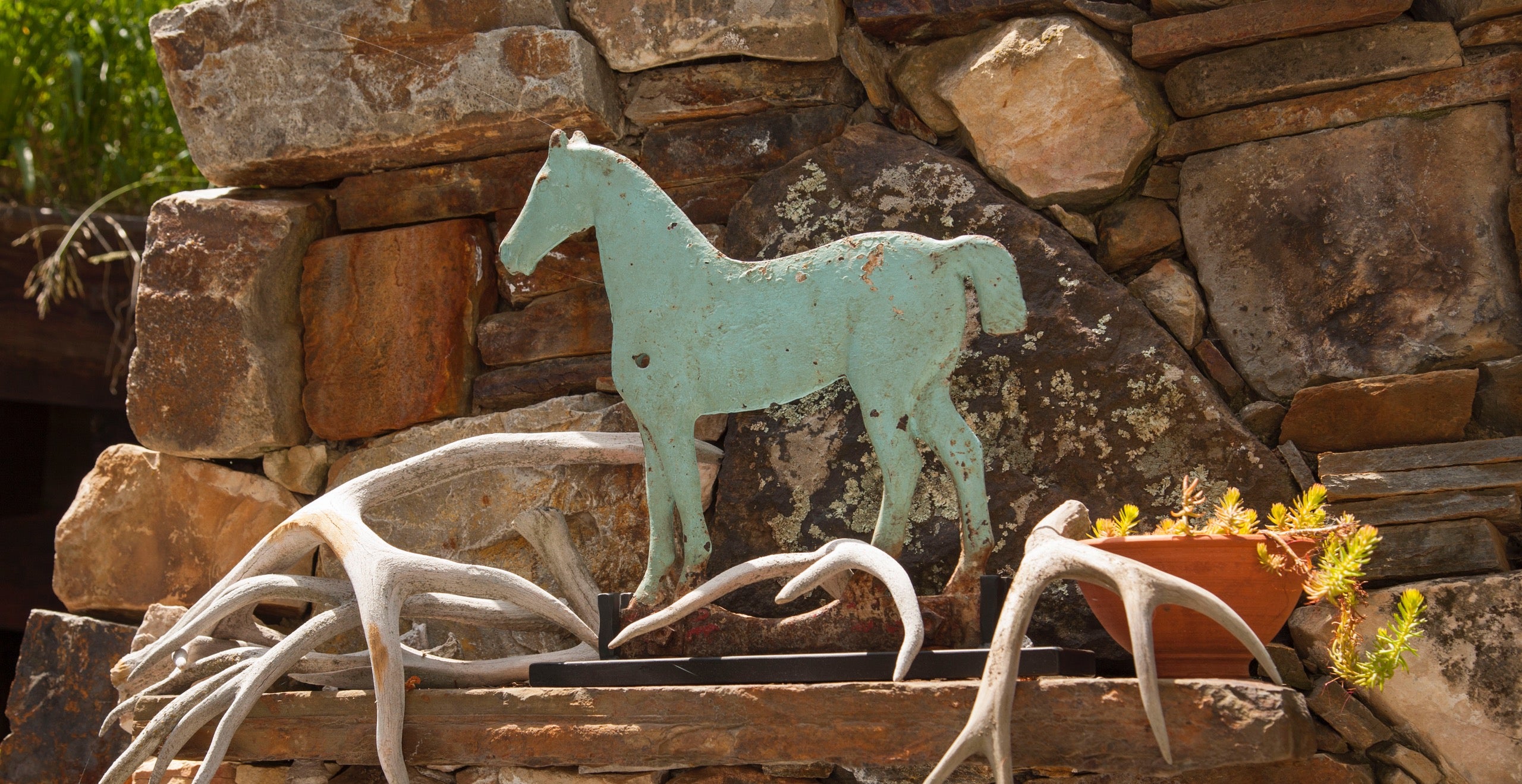 Buffy Birrittellas rustikales Ferienhaus in Utah beherbergt eine gro&szlig;e Sammlung an Pferden &ndash; Pferde, die sie reitet und Pferde, die sie sammelt. Hier sehen Sie eine blaue Pferde-Windm&uuml;hle umgeben von Geweihen