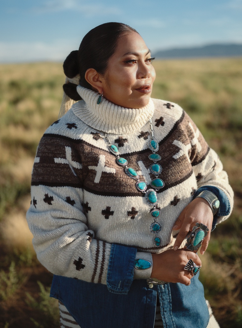  <strong>NAIOMI GLASSES</strong><br/> <span>Textilkünstlerin, Designerin und Model der Diné (Navajo) in der siebten Generation. Nachdem sie in ihrer Kindheit von Phoenix, Arizona, nach Dinétah (Navajo Nation) umzogen war, beschäftigte sich Naiomi unter Anleitung ihrer Großmutter intensiv mit dem traditionellen Weben. Die mittlerweile 26-jährige Naiomi wird regelmäßig auf dem Santa Fe Indian Market und dem Heard Guild Indian Fair & Market der SWAIA (Southwestern Association for Indian Arts) vorgestellt, wo ihre Werke eine Reihe von Auszeichnungen und Anerkennungen erhalten haben, unter anderem mehrere Preise in verschiedenen Textil- und Webkategorien</span>  