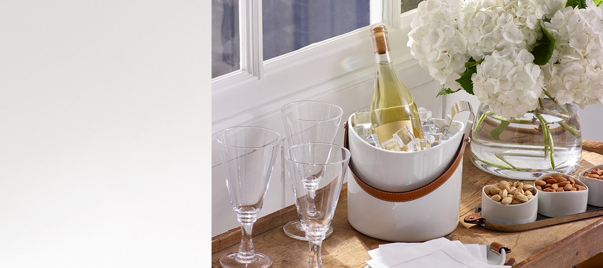 Wine bottle on ice next to flowers & bowls of nuts